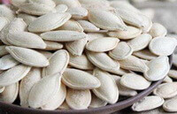 many dried whitish herb seeds of Semen Cucurbitae are piled in a plate