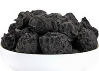 blackish dried fruits of Smoked Plum are piled in a small plate