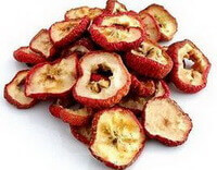 some yellowish dried fruit slices of Fructus Crataegi with reddish fruit peel are piled together