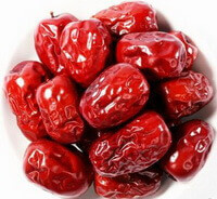 many dried red fruits of jujube fruit are piled in a plate